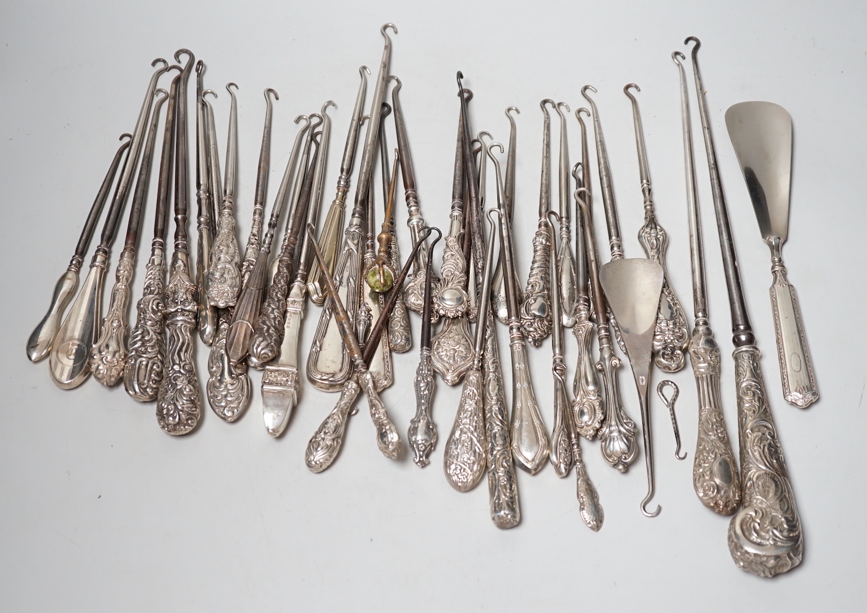 A large collection of mainly silver handled button hooks and two shoe horns.